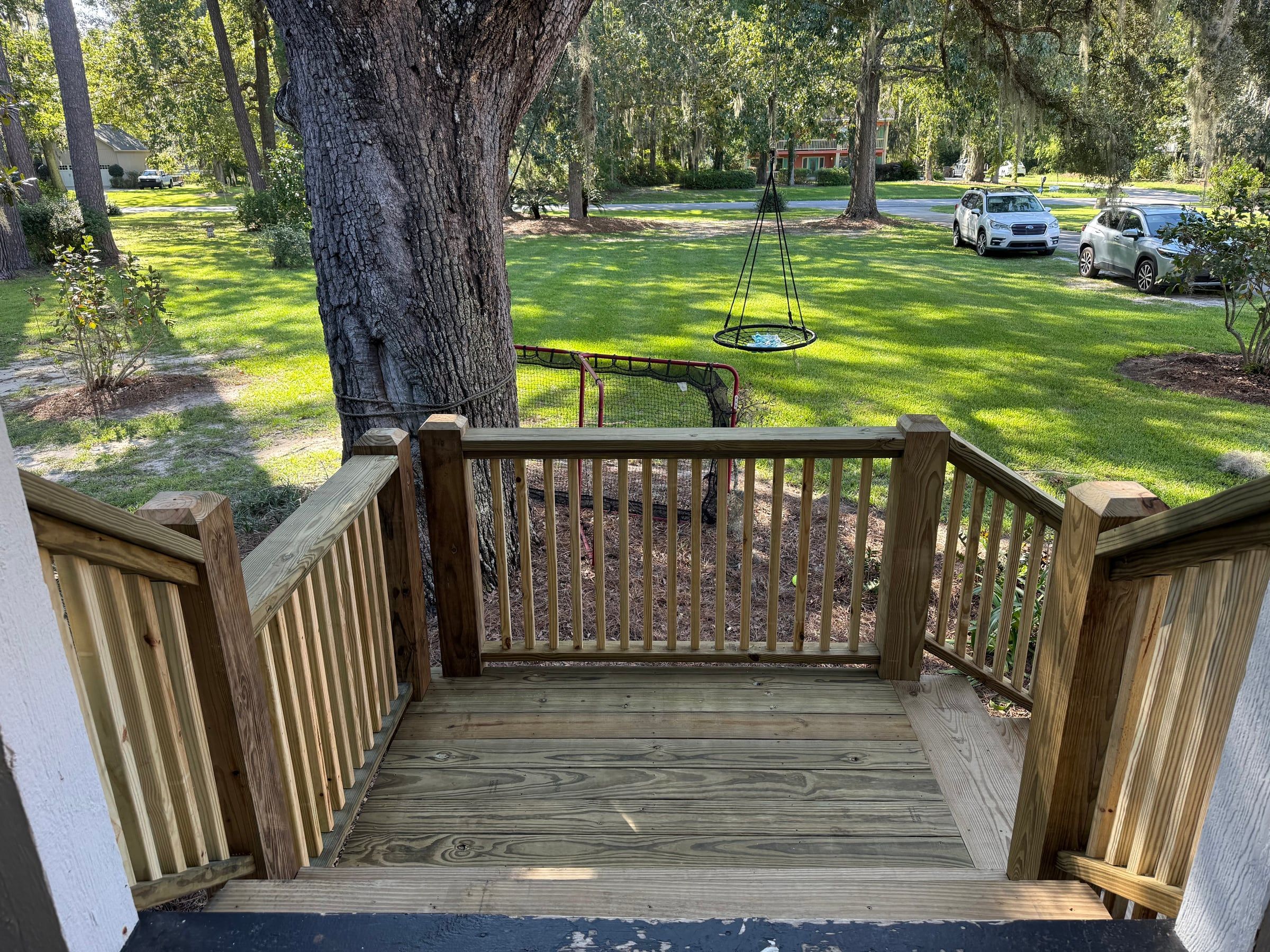 View from a new porch landing with railings out over a green front yard