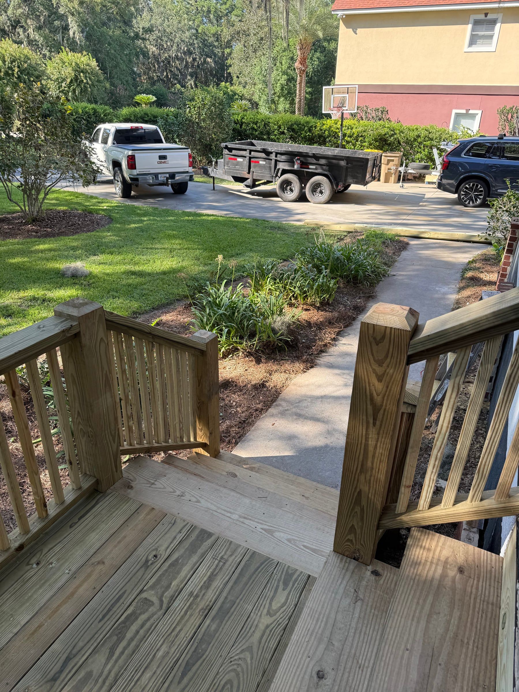 New porch stair railings leading down to a concrete walkway